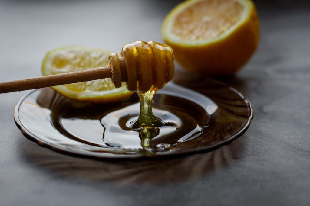 The Art of Drawing Readers In: Your attractive post title goes here A close-up of a honey dipper with fresh lemon slices on a saucer, showcasing warm, natural lighting.