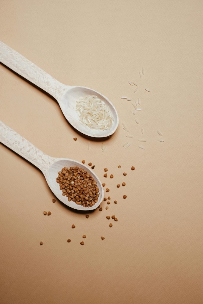 Close-up view of spoons with organic buckwheat and rice, perfect for healthy living concepts.