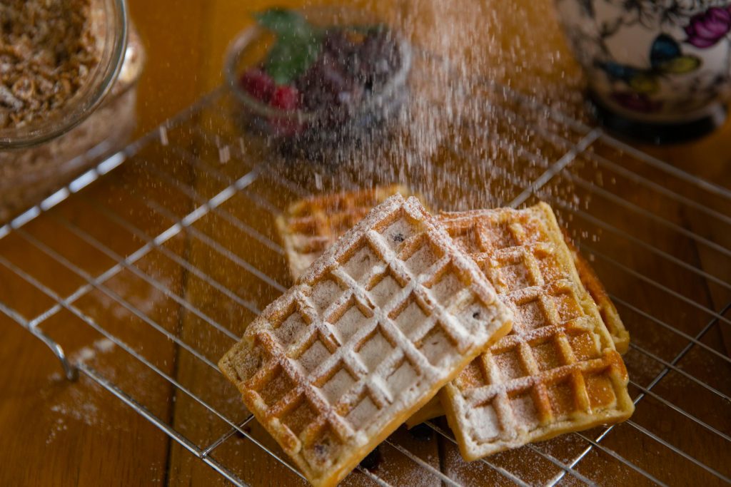 Remplacer le gluten : 10 alternatives saines et faciles Close-up of crispy waffles sprinkled with powdered sugar, perfect for a sweet breakfast.